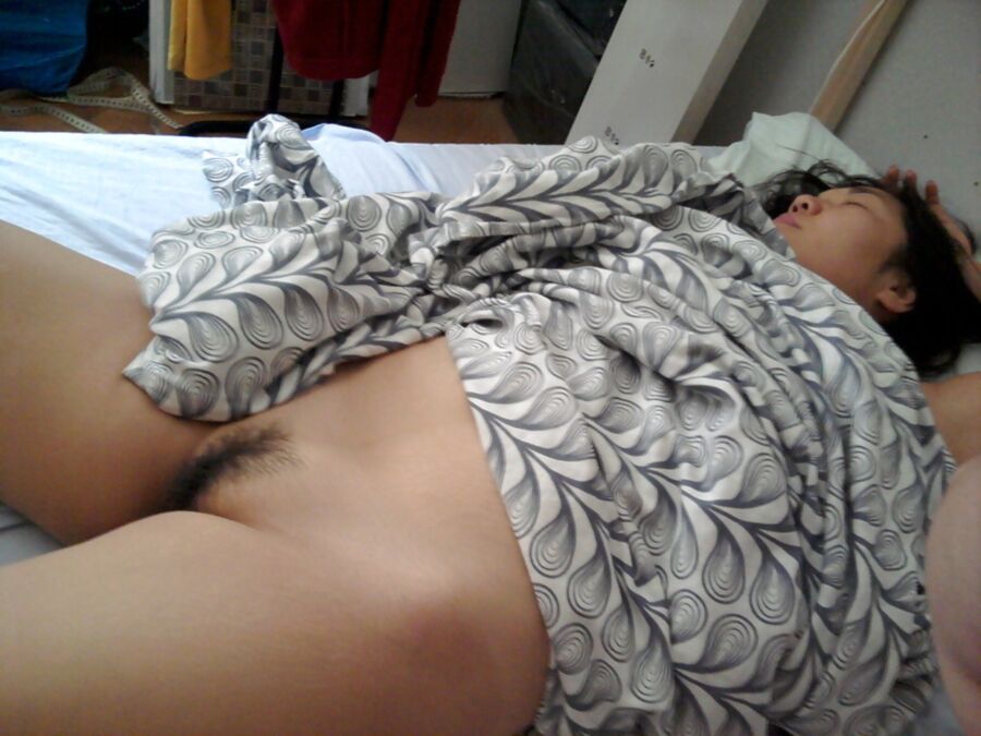 Femme asiatique nue sur le lit