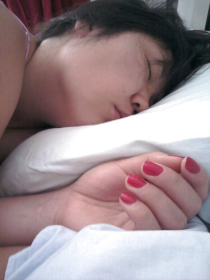 Femme asiatique nue sur le lit