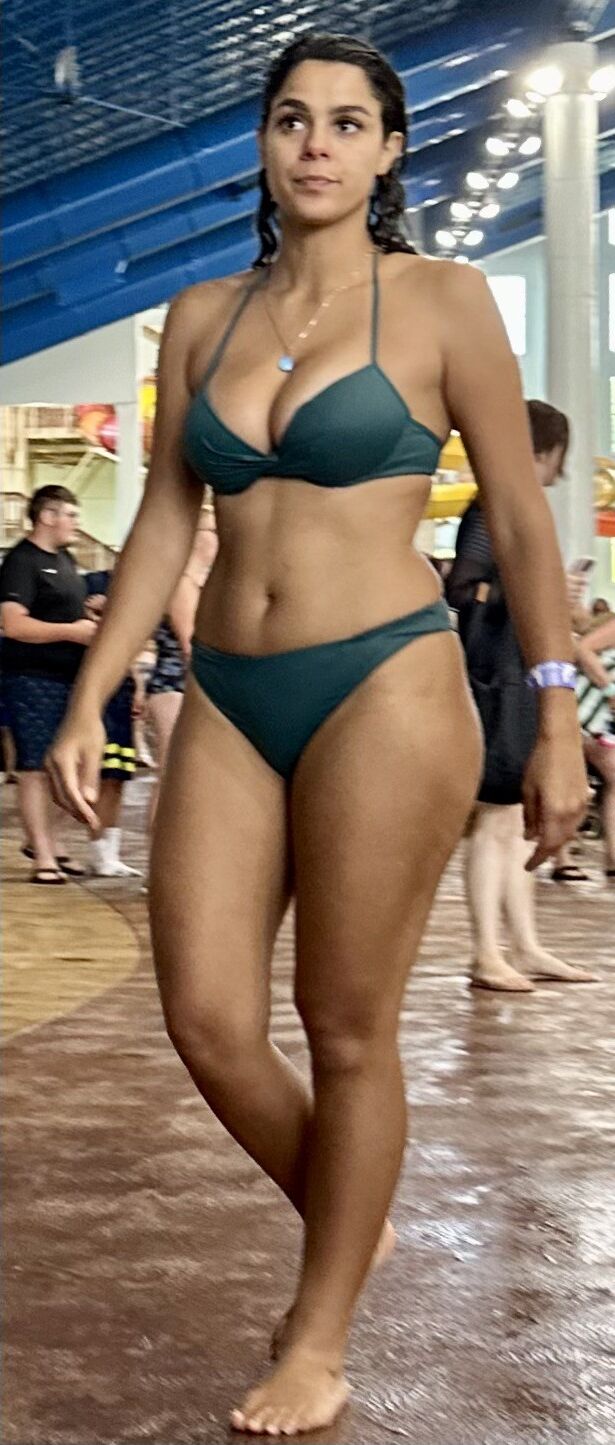 Latina de cabello cuervo en bikini verde bebiendo daiquiri