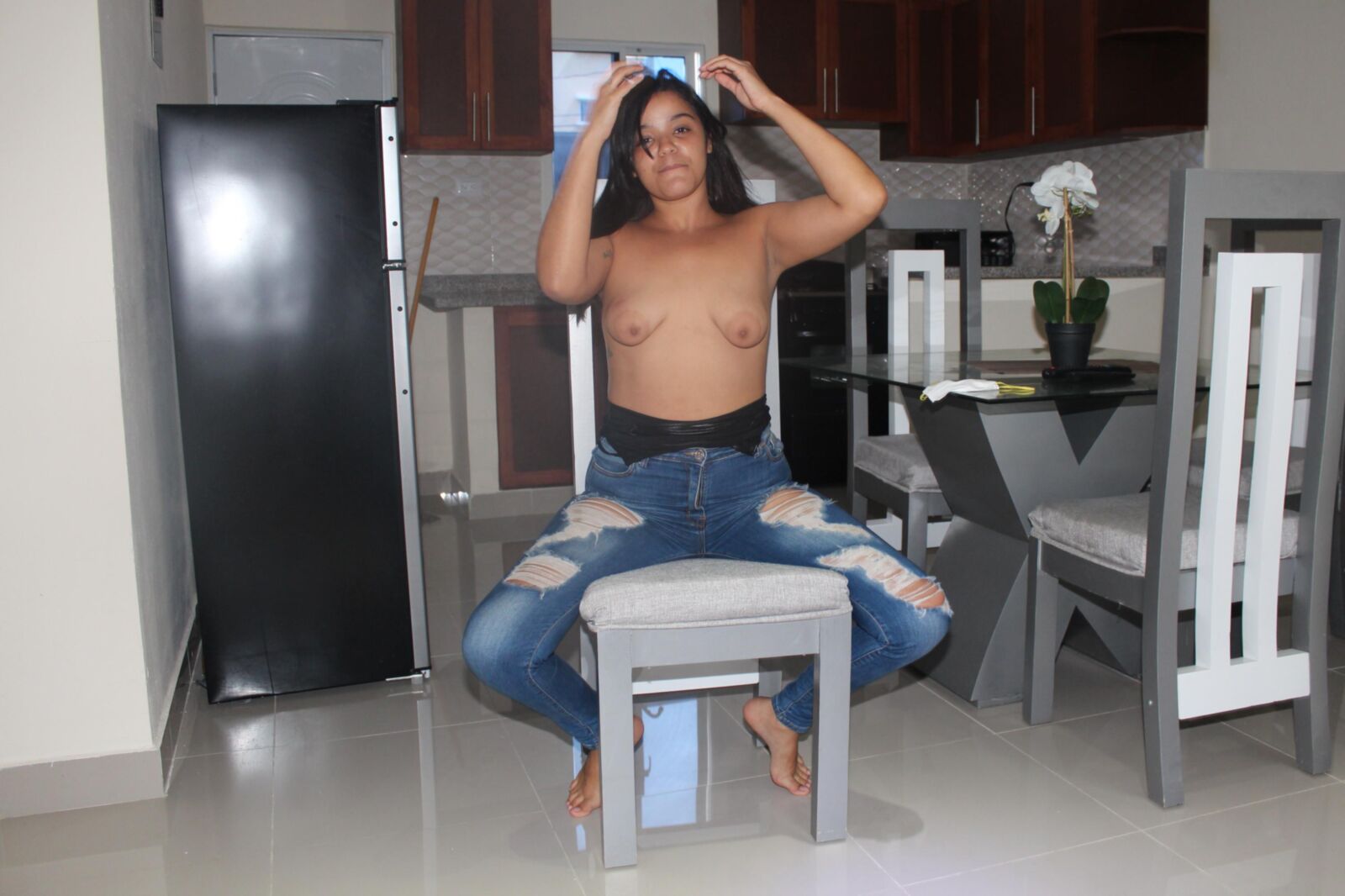 Latina sexy posa de topless em jeans azul