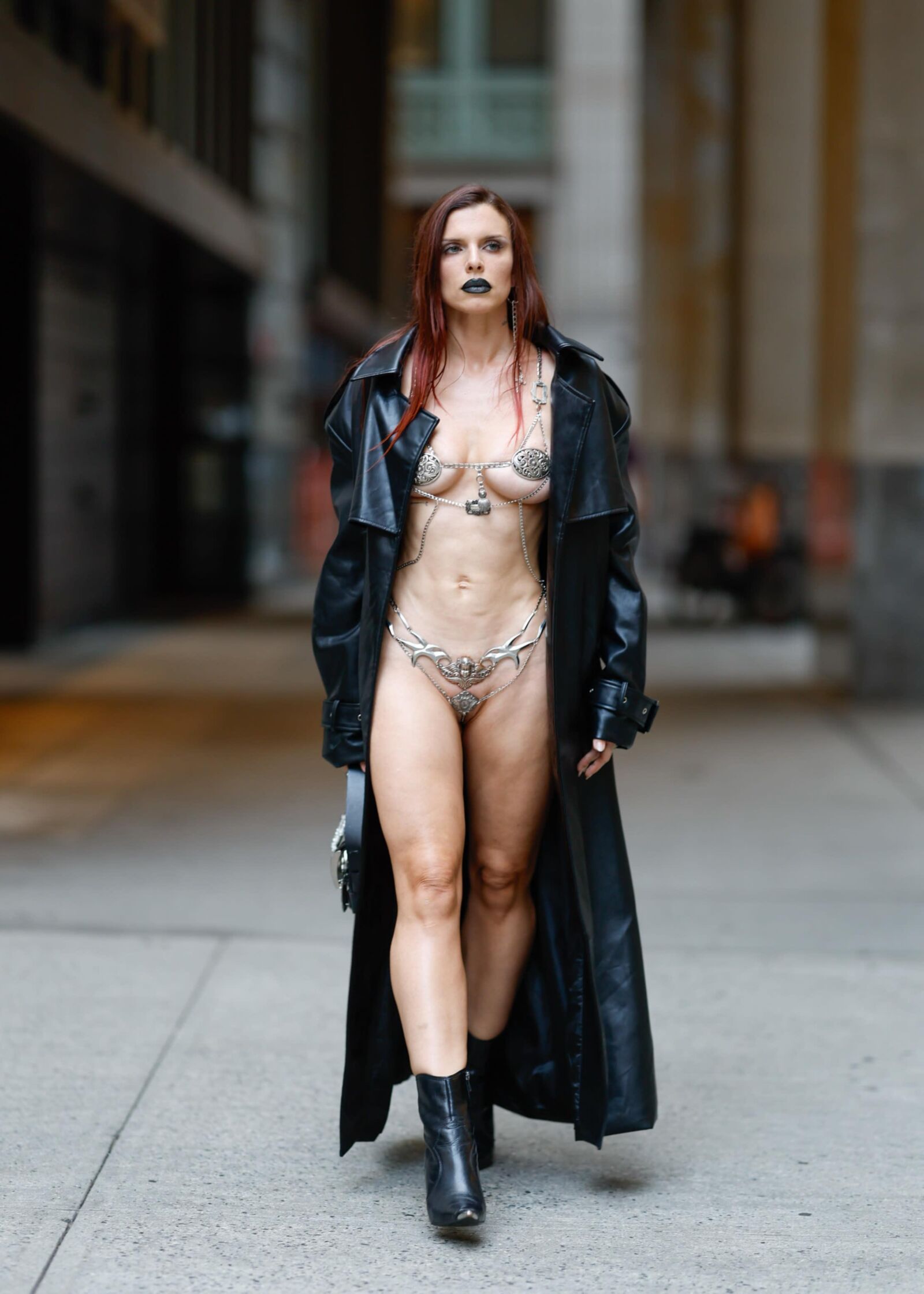 Julia fox wearing a sexy chain outfit under a black trench coat 
