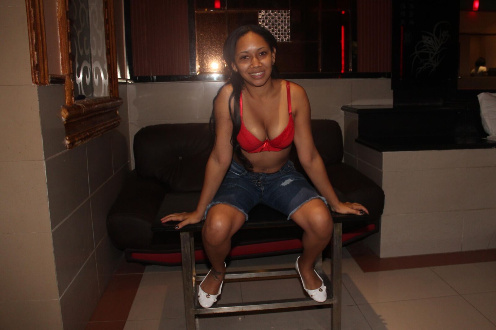 Pretty Latina abaixa seu sutiã vermelho para fazer uma provocação quente